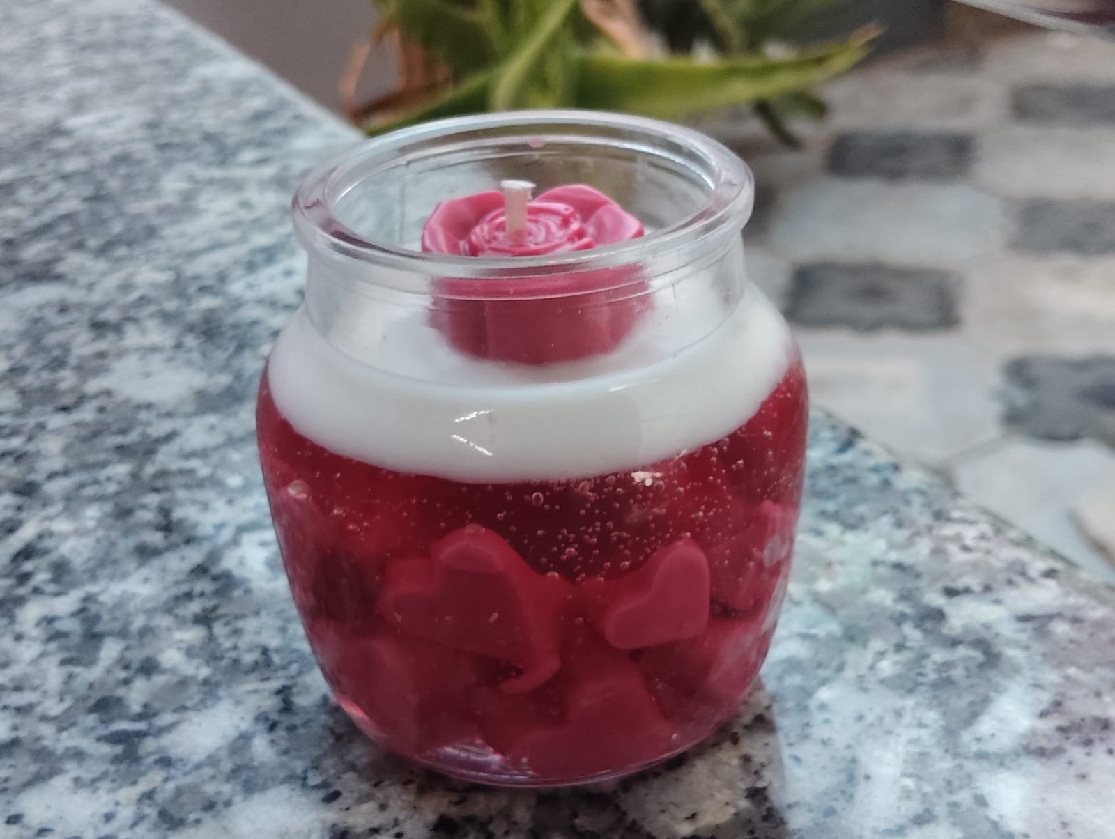 Candle topped with a hand-shaped rose